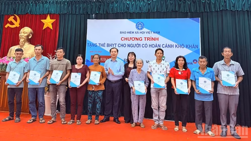 Ông Chu Mạnh Sinh, Phó Giám đốc Bảo hiểm xã hội Việt Nam (thứ sáu từ trái sang) và bà Nguyễn Thị Thanh Xuân,Giám đốc Bảo hiểm xã hội thành phố Cần Thơ (thứ bảy từ trái sang) trao tặng thẻ bảo hiểm y tế cho người dân có hoàn cảnh khó khăn trên địa bàn phường Hưng Phú. 
