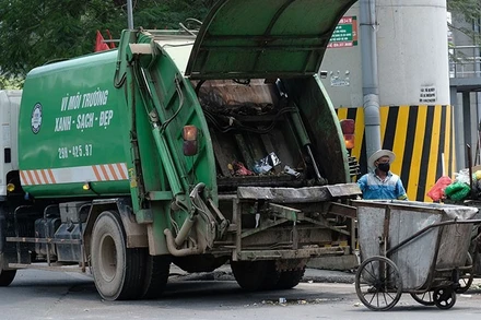Công nhân Công ty Môi trường đô thị Hà Nội thu gom rác thải ở quận Đống Đa. (Ảnh: PHẠM HÙNG)
