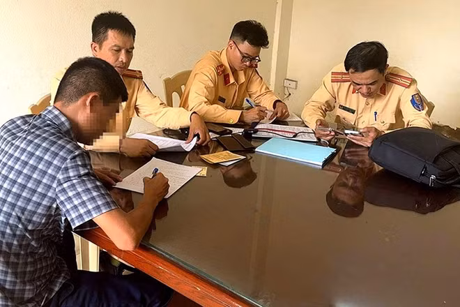Cảnh sát giao thông lập biên bản về hành vi vi phạm của người điều khiển ô-tô.