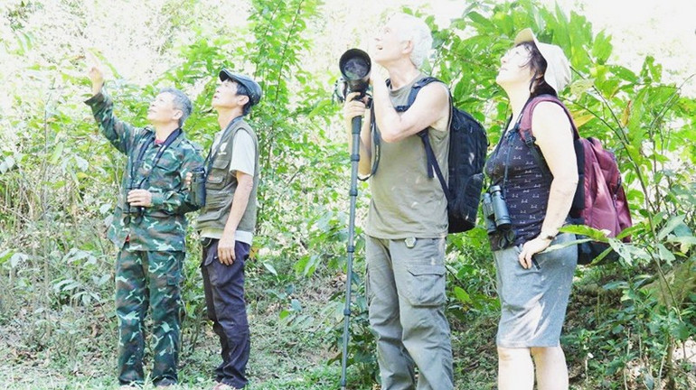 Giám đốc HTX Nguyễn Thanh Tú (bên trái) hướng dẫn khách quốc tế quan sát đàn voọc. 62.jpg