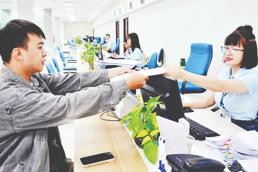 Cán bộ Trung tâm Phục vụ hành chính công tỉnh Quảng Ninh tiếp nhận, xử lý hồ sơ của công dân. (Ảnh THANH HOA)