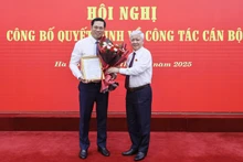 Đồng chí Đỗ Văn Chiến (bên phải) tặng hoa chúc mừng đồng chí Bùi Duy Đông.