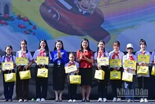 Bí thư Trung ương Đoàn, Chủ tịch Hội đồng Đội Trung ương Nguyễn Phạm Duy Trang (thứ 5 từ trái sang) cùng đại diện Ban tổ chức Ngày hội trao học bổng tặng thiếu nhi vượt khó học tốt.