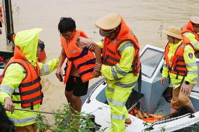 Lực lượng công an hỗ trợ người dân di chuyển khỏi vùng ngập.