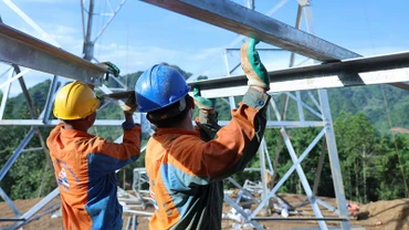 Để hoàn thành một cột điện, các công nhân phải lắp ghép cả trăm tấn kết cấu thép.