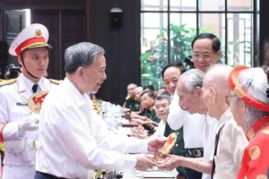 Tổng Bí thư Tô Lâm tặng quà cho cán bộ lão thành cách mạng. (Ảnh: TTXVN)