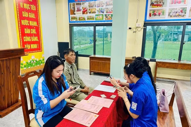 Đoàn viên thanh niên xã Cẩm Bình, tỉnh Hà Tĩnh hướng dẫn người dân làm hồ sơ trực tuyến.
