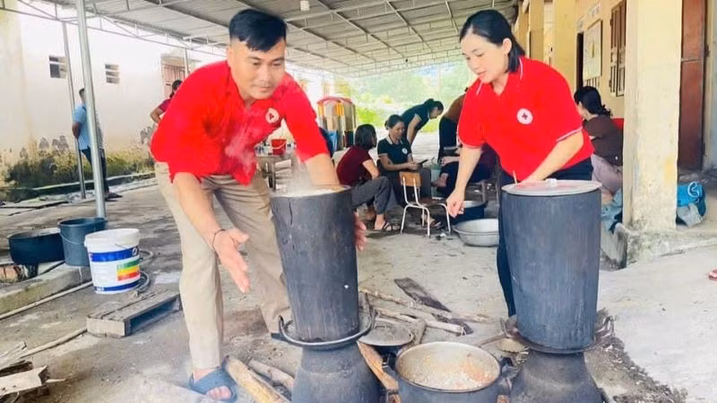 Các tình nguyện viên Chữ thập đỏ tham gia nấu cơm hỗ trợ các hộ sơ tán tại Nghệ An. 