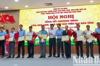 Chủ tịch Ủy ban nhân dân tỉnh Cà Mau Phạm Thành Ngại (giữa) tặng Bằng khen cho các tập thể đóng góp tích cực thực hiện Chương trình xóa nhà tạm, nhà dột nát.