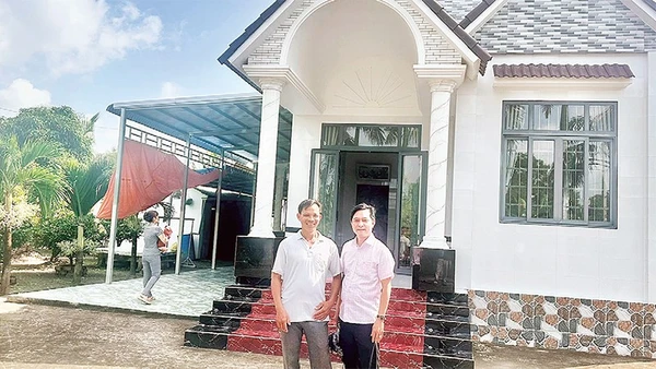 Nông dân Trần Quốc Thống (bên trái) trồng lúa ST 25 kết hợp nuôi tôm, mỗi năm thu lãi hơn một tỷ đồng, vừa xây nhà mới khang trang.