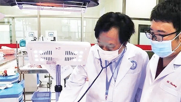 Giáo sư, Tiến sĩ, Thầy thuốc Nhân dân, Anh hùng Lao động thời kỳ đổi mới Tạ Văn Trầm (bên trái) khám bệnh cho bệnh nhi.