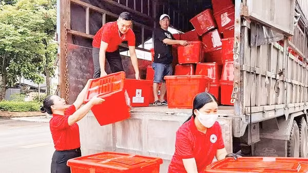 Cán bộ Hội Chữ thập đỏ Sơn La hỗ trợ tiền, vật dụng thiết yếu cho các hộ bị thiên tai tại xã Pắc Ngà. 