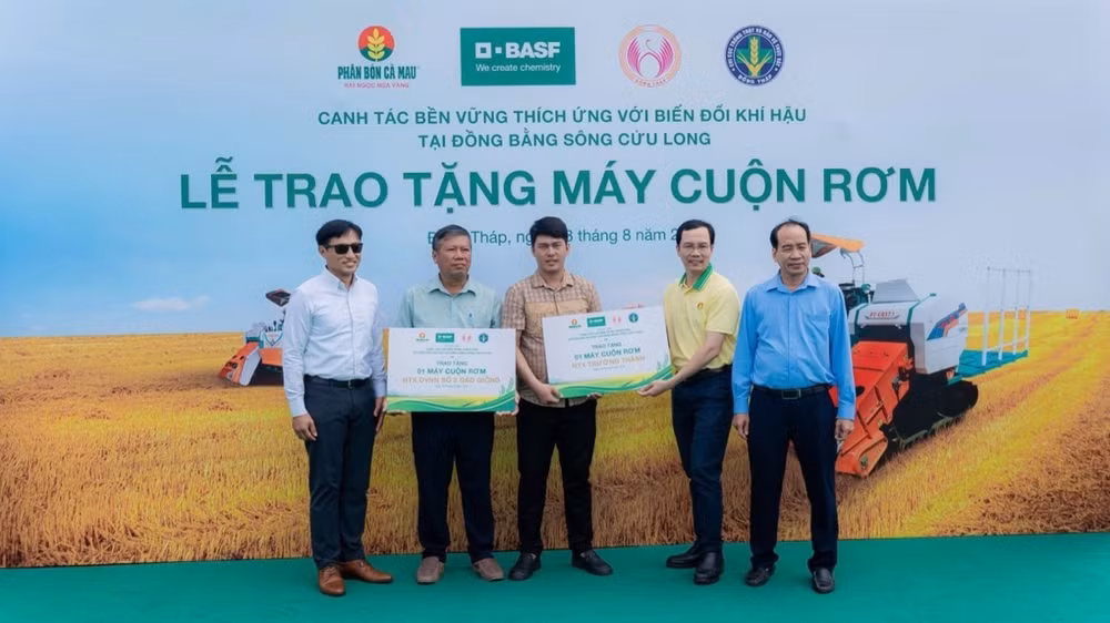 Đại diện các hợp tác xã nhận máy cuộn rơm từ chương trình. (Ảnh: Đạm Cà Mau)