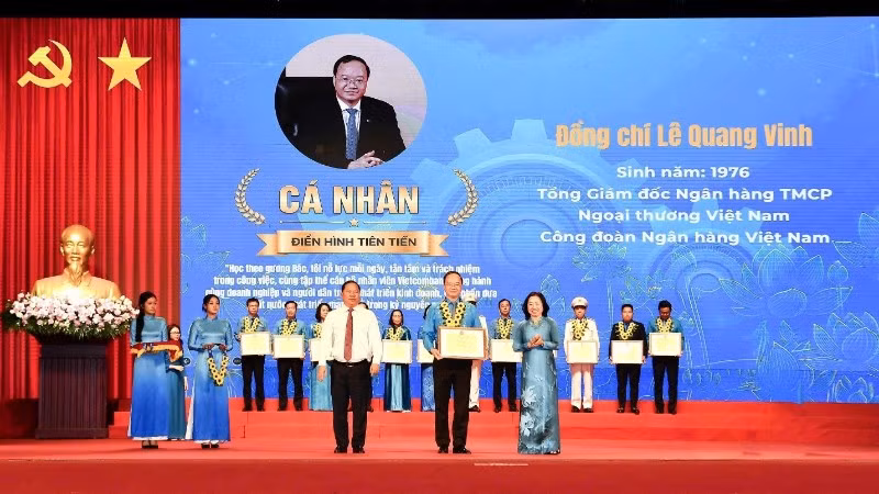 Đồng chí Nguyễn Phi Long, Ủy viên Trung ương Đảng, Phó Bí thư Thường trực Đảng ủy Mặt trận Tổ quốc các đoàn thể Trung ương, Phó Chủ tịch Ủy ban Trung ương Mặt trận Tổ quốc Việt Nam (bên trái) trao hoa chúc mừng và đồng chí Thái Thu Sương, Phó Chủ tịch thường trực Tổng Liên đoàn Lao động Việt Nam (bên phải) trao bằng khen cho đồng chí Lê Quang Vinh.
