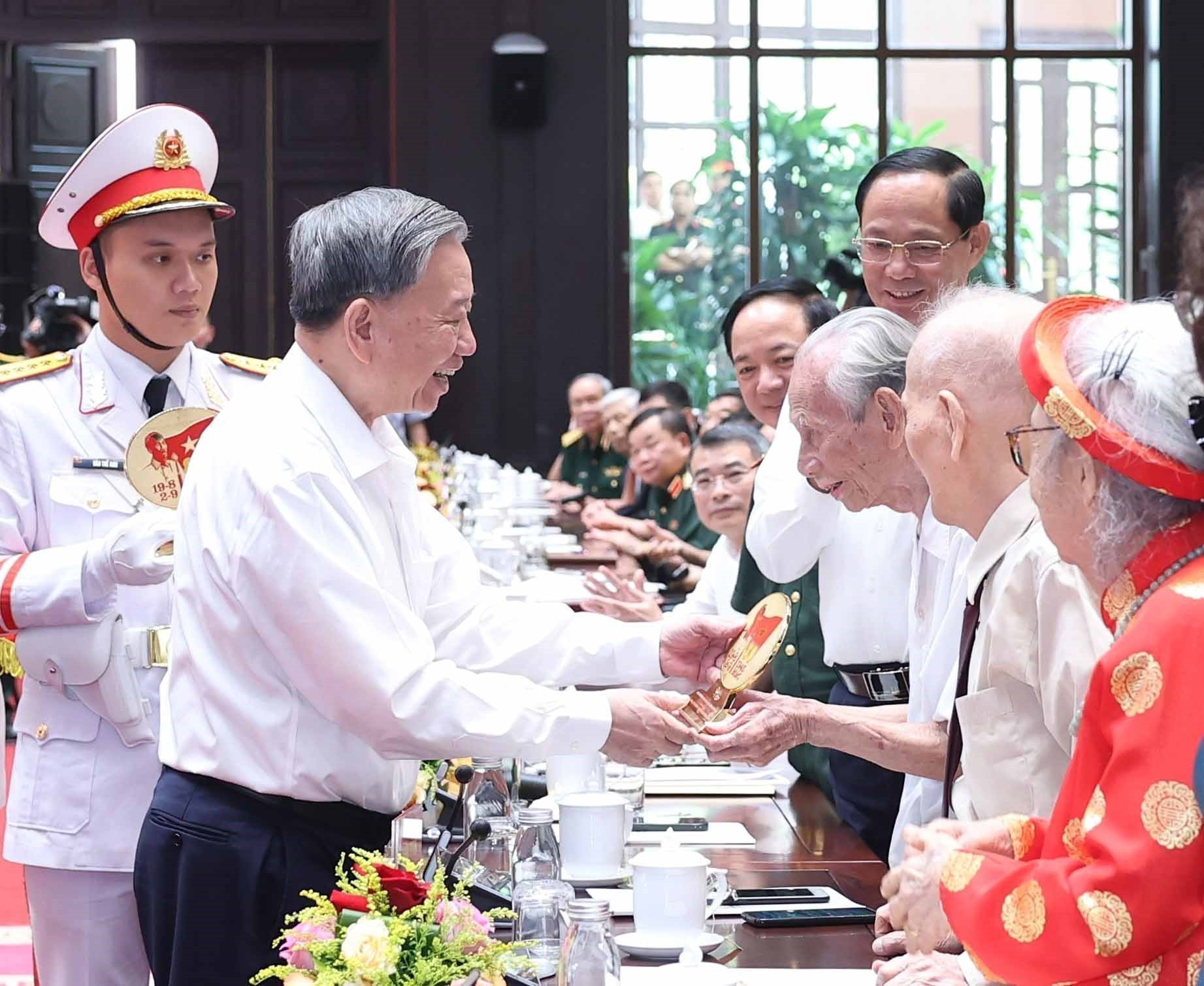 Tổng Bí thư Tô Lâm tặng quà cho cán bộ lão thành cách mạng. (Ảnh: TTXVN)