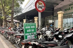 Điểm trông giữ xe máy trên hè phố Phủ Doãn, khiến người đi bộ buộc phải đi xuống lòng đường, rất nguy hiểm.