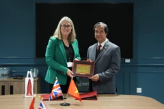 Bộ trưởng Nguyễn Kim Sơn và Thứ trưởng Jacqui Smith trao quà lưu niệm. (Ảnh: TTXVN)