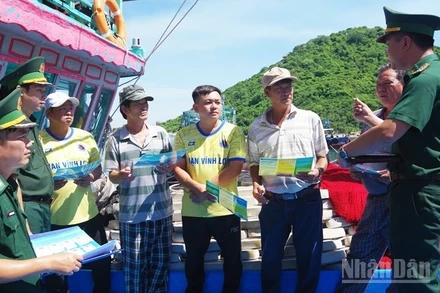 Cán bộ Đồn Biên phòng Cát Khánh, Bộ đội Biên phòng tỉnh Gia Lai tuyên truyền pháp luật cho ngư dân trước khi xuất bến.