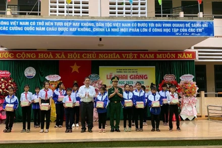 Đại diện xã Ia O và Ban Chỉ huy Bộ đội Biên phòng tỉnh trao quà cho các em học sinh tại lễ khai giảng.