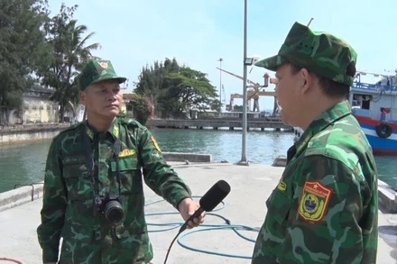 Thiếu tá quân nhân chuyên nghiệp Văn Công Cường (bến trái) trong một lần tác nghiệp.