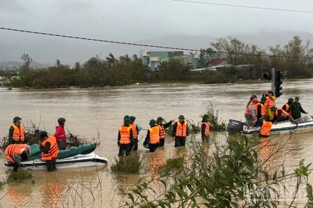 Ca-nô cứu hộ vượt dòng nước xiết trong mưa gió tiến vào khu dân cư bị cô lập.