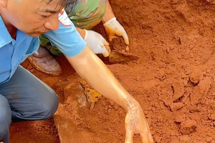 Cán bộ, chiến sĩ Đội K52 phối hợp với Ban Chỉ huy quân sự xã Ia Boòng cẩn thận cất bốc hài cốt liệt sĩ.