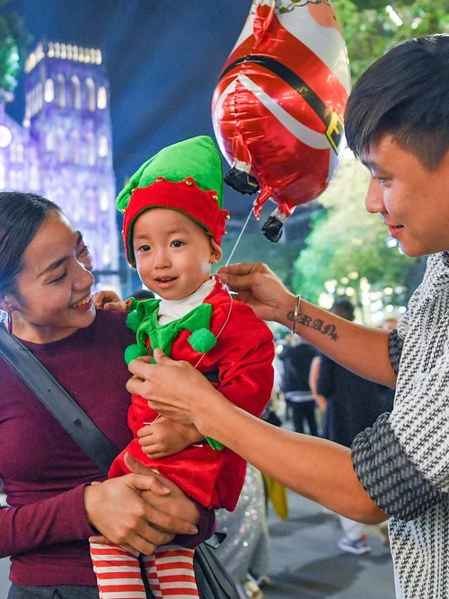 Gia đình đưa trẻ nhỏ đi đón Noel tại Nhà thờ Lớn.