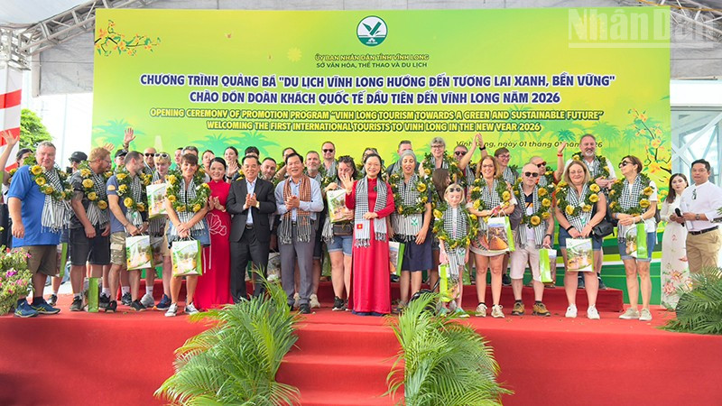 Lãnh đạo tỉnh Vĩnh Long trao quà cho khách quốc tế đầu tiên đến Vĩnh Long. 