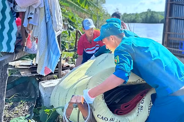 Lực lượng chức năng và đoàn thể xã Đất Mới (tỉnh Cà Mau) hỗ trợ giúp dân khắc phục hậu quả sau sạt lở đất.