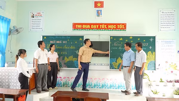Cán bộ, giáo viên Trường tiểu học Tân Quới và cán bộ Phòng Văn hóa-Thông tin xã Tân Long kiểm tra cơ sở vật chất tại một phòng học của trường. (Ảnh: HỮU NGHĨA)