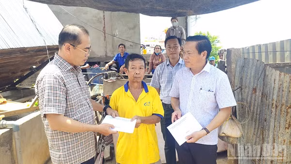 Trao tiền hỗ trợ hộ gia đình bị thiệt hại do thiên tai.