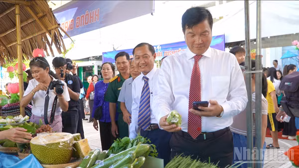 Đồng chí Võ Phan Thành Minh, Bí thư Đảng ủy phường Mỹ Ngãi cùng đại biểu, bà con nhân dân tham quan, trải nghiệm mặt hàng nông sản dán mã QR truy xuất nguồn gốc.