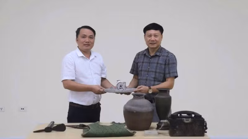 Phó Giám đốc Bảo tàng tỉnh Quảng Trị Mai Thế Trung (áo trắng) trao hiện vật, tư liệu phục vụ xây dựng Bảo tàng Đảng Cộng sản Việt Nam 