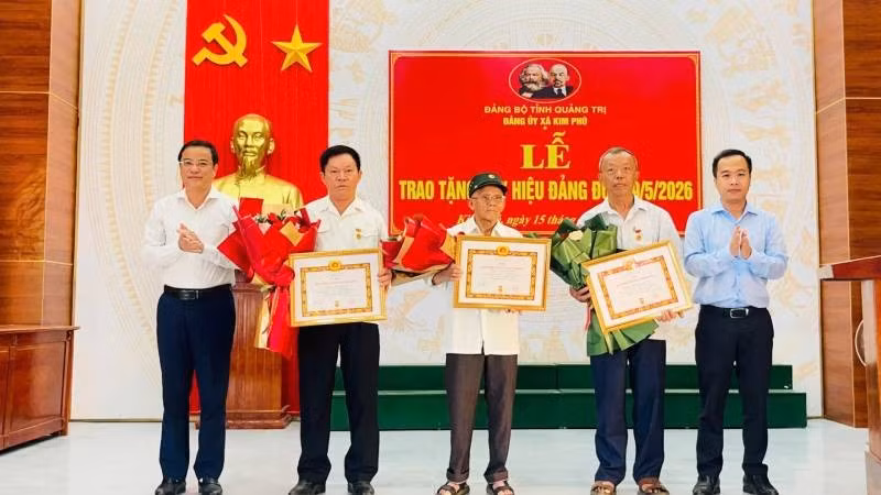 Thường trực Đảng ủy xã Kim Phú, tỉnh Quảng Trị trao Huy hiệu Đảng và tặng hoa chúc mừng các đảng viên.