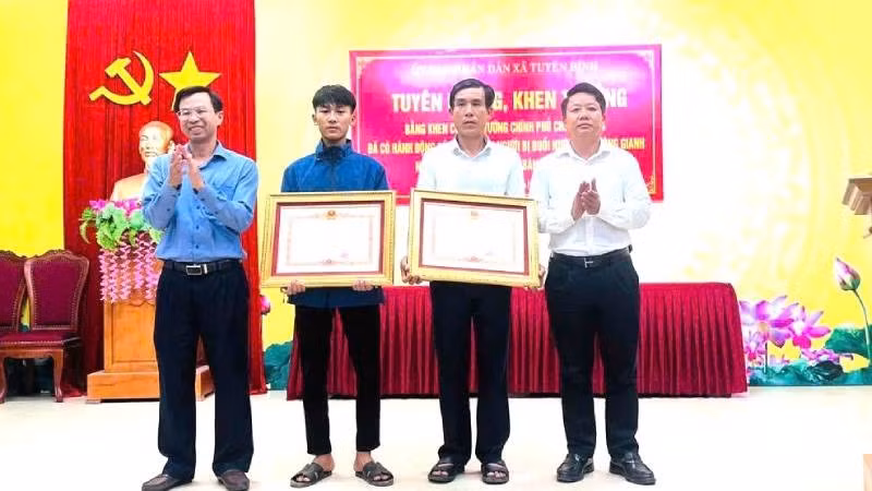 Bố con ông Cao Hữu Tình và em Cao Hoàng Ân Đức nhận Bằng khen của Thủ tướng Chính phủ vì đã có hành động dũng cảm cứu người đuối nước trên sông Gianh.