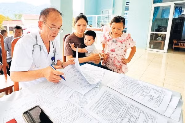 Bác sĩ Nông Văn Lực khám bệnh cho trẻ em tại Trạm y tế xã Bạch Thông.