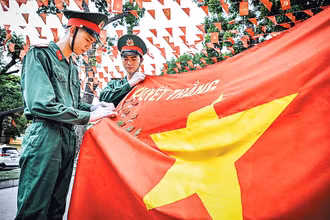 Các chiến sĩ tiêu binh danh dự cài huy chương trên Quân kỳ quyết thắng. (Ảnh: THÀNH ĐẠT)