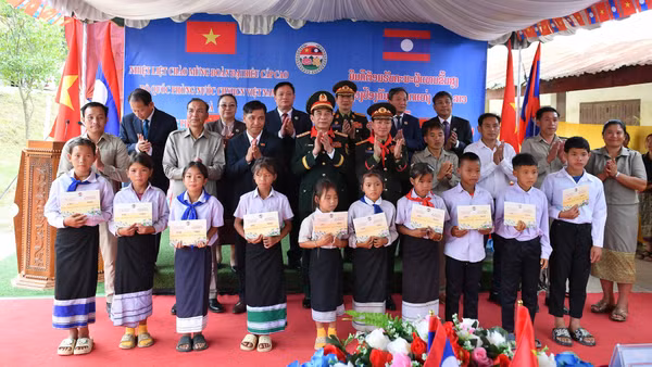 Đại tướng Phan Văn Giang và Đại tướng Khamliang Outhakaysone trao quà tặng các em học sinh Trường tiểu học Thongnammoun.
