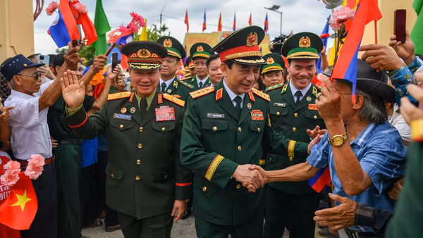 Bà con nhân dân biên giới chào mừng hai Phó Thủ tướng, Bộ trưởng Quốc phòng Việt Nam-Lào đến dự lễ sơ kết kết nghĩa cụm dân cư hai bên biên giới.