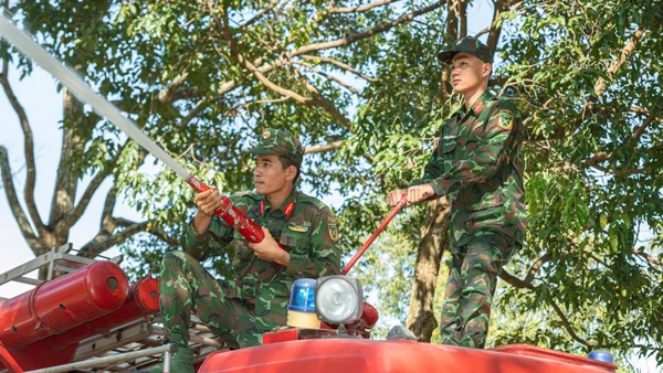 Chiến sĩ phối hợp điều khiển vòi cứu hỏa, yêu cầu một người giữ chắc đầu vòi hướng thẳng vào đám cháy, người còn lại giữ thân vòi tạo lực ổn định.
