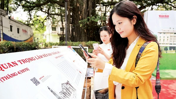 Các bạn trẻ quét mã QR xem thông tin các trận đánh tại triển lãm tương tác do Báo Nhân Dân tổ chức dịp kỷ niệm 50 năm Ngày Giải phóng miền nam, thống nhất đất nước. Ảnh | THẾ ĐẠI