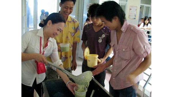 Chị Hồ Phương Thảo phát cháo cho bệnh nhân nghèo.