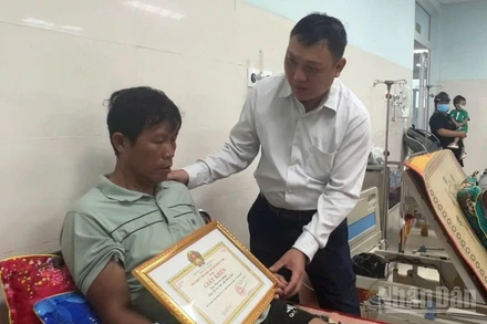 Chủ tịch Ủy ban nhân dân đặc khu Lý Sơn Nguyễn Văn Huy thăm hỏi, trao tặng Giấy khen cho ông Phan Duy Quang.