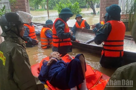 Quân đội giúp đưa người già ra khỏi khu vực ngập sâu đến nơi an toàn. 