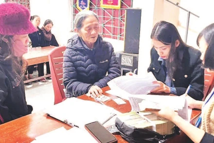 Cán bộ xã Tuyên Sơn, tỉnh Quảng Trị chi trả tiền quà Tết, tặng người dân.