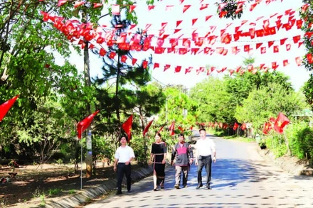 Các tuyến đường dẫn vào buôn Tuôr, xã Hòa Phú rợp đỏ màu cờ Tổ quốc chào mừng Đại hội XIV của Đảng.