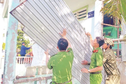 Lực lượng tình nguyện Công an tỉnh Cà Mau giúp người dân tháo dỡ nhà tạm, nhà dột nát.