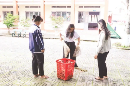 Học sinh Trường THPT Dân tộc nội trú Nơ Trang Lơng, tỉnh Đắk Lắk quét dọn vệ sinh khuôn viên nhà trường phòng chống dịch bệnh.
