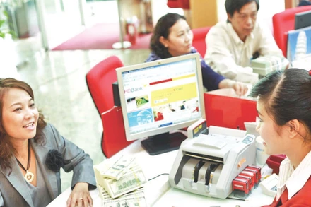 Khách hàng giao dịch kiều hối ở ngân hàng tại Thành phố Hồ Chí Minh. (Ảnh THẾ ANH)