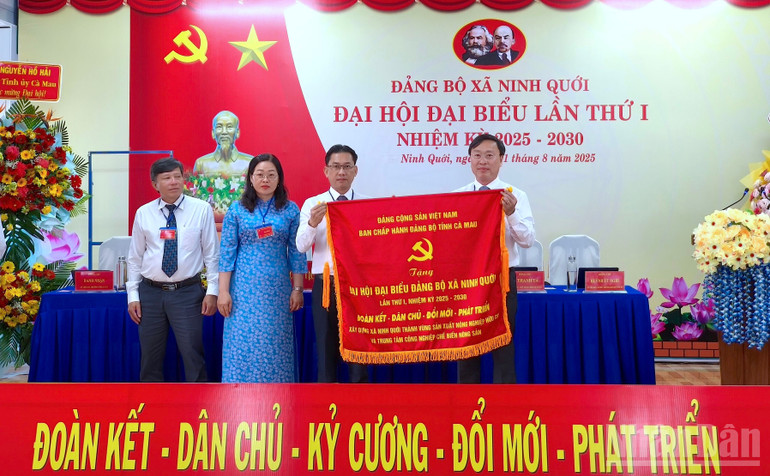 Phó Chủ tịch Ủy ban nhân dân tỉnh Cà Mau Huỳnh Hữu Trí (bên phải) tặng bức trướng của Ban Chấp hành Đảng bộ tỉnh mừng Đại hội đại biểu lần thứ nhất Đảng bộ xã Ninh Quới. ndo_br_ninh-quoi-10.jpg